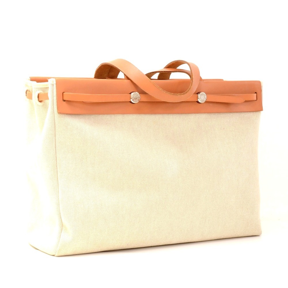 HERMES, Beige canvas and tan leather tote bag. With its …
